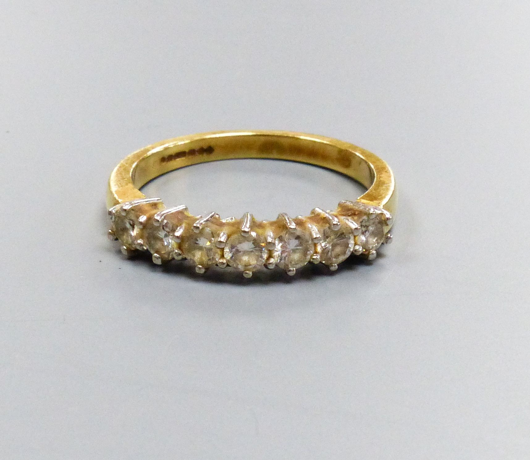 A modern 18ct gold and seven stone diamond set half hoop ring, size P/Q, gross weight 4.4 grams.